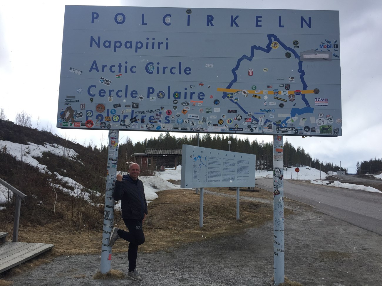 Nein, beim unterm Schild herumstehenden Typen handelt es sich um keine mutierte Bordsteinschwalbe sondern um einen bestens aufgelegten Tomasz am Polarkreis (präzise ausformuliert am Polarkreis-Info-Zentrum an der E45)